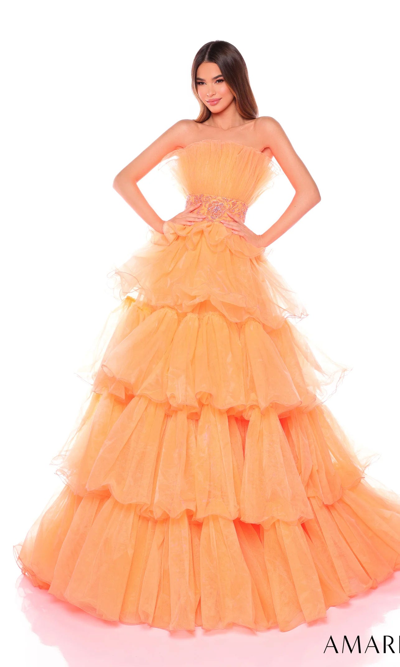 A woman poses against a plain white background wearing the Long Formal Dress 88083 by Amarra, a strapless ball gown featuring ruffled tiers and a decorative beaded waist.